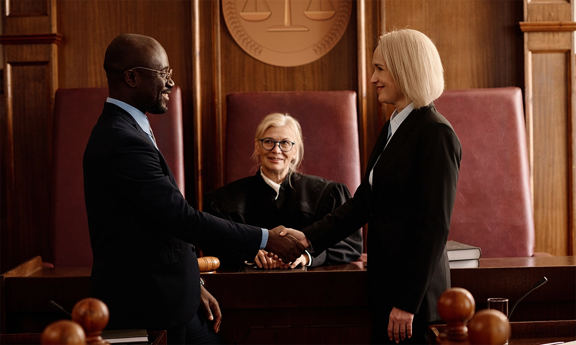 Two Lawyers shaking hands in front of a Judge